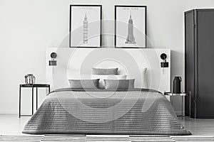 Monochromatic bedroom interior with posters