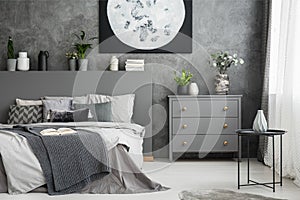 Monochromatic grey bedroom interior with a bed with linen and pi