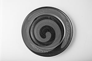 Monochromatic image. Top view of a black pastel plate on a pastel white background. Minimalism food photography. Geometric style.