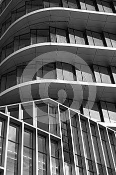 Monochrome architecture, curved lines of a modern building facade, pattern of windows and balconies,