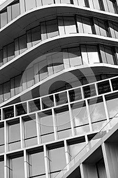 Monochrome architecture, curved lines of a modern building facade, pattern of windows and balconies,