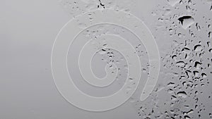 Monochrome background of wet glass with dripping droplets and copy space