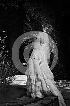 Monochrome bride next to fountain