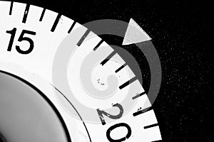 monochrome close-up of an old analog laboratory timer set to 18