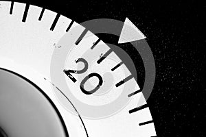 monochrome close-up of an old analog laboratory timer set to 20