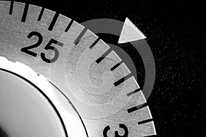 monochrome close-up of an old analog laboratory timer set to 27