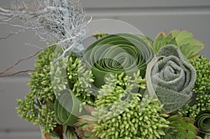 Monochrome designer bouquet of green flowers and transformed leaves, close-up. Floral design