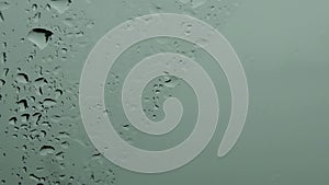 Monochrome green grey background of wet glass with dripping droplets and copy space