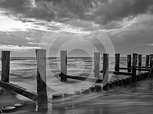 Monochrome image of a breakwater in the Baltic Sea near to Zingst, Mecklenburg-Western Pomerania, at twilight