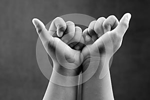 Monochrome image of closed hands of a kid for concepts of strength and unity