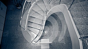 Monochrome image of curved stoned staircase at modern building