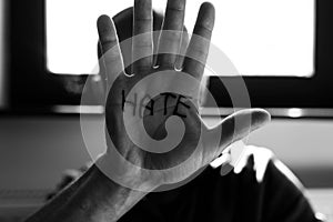 Monochrome image, man in front of a bright window showing hes palm