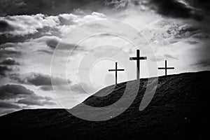 Monochrome image of three crosses sitting on a hill