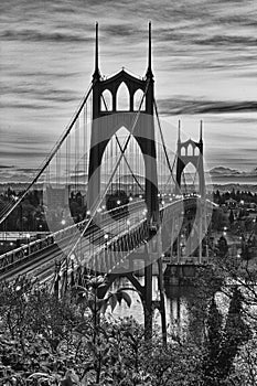 Monochrome image of a train crossing a river on a bridge
