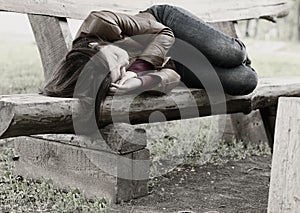 Monochrome image of a woman on a park bench