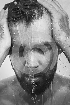 Monochrome image of young frustrated man under shower