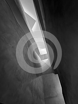 Abstract black and white architectural atrium with light beams through angled walls