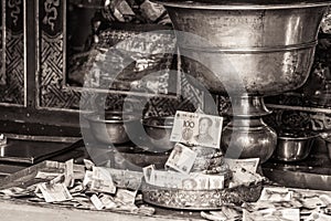 Monochrome photo of bowl in temple of Kumbum monastery for collecting money, Xining, China