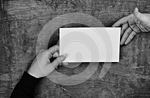 Monochrome photo male hands holding a white blank sheet of paper