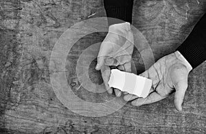 Monochrome photo male hands holding a white blank sheet of paper