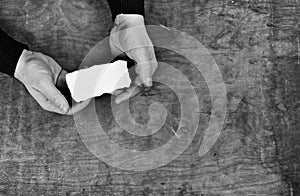 Monochrome photo male hands holding a white blank sheet of paper