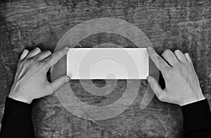 Monochrome photo male hands holding a white blank sheet of paper