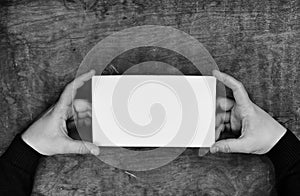 monochrome photo male hands holding a white blank sheet of paper