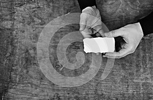 Monochrome photo male hands holding a white blank sheet of paper