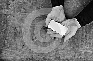 Monochrome photo male hands holding a white blank sheet of paper