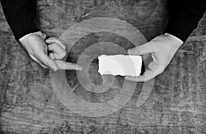 Monochrome photo male hands holding a white blank sheet of paper