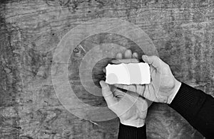 Monochrome photo male hands holding a white blank sheet of paper