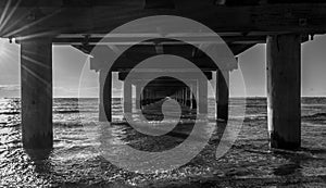 Monochrome photo of sea under the pier