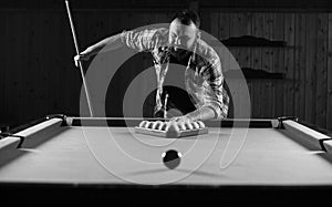 Monochrome photo young man playing billiards