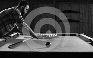 Monochrome photo young man playing billiards