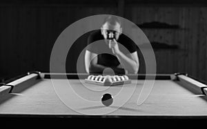 Monochrome photo young man playing billiards