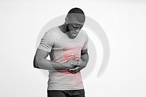 Monochrome photo of young man suffering from stomach ulcer