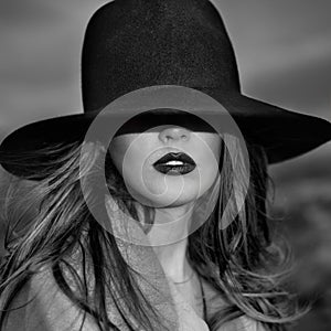 Monochrome portrait of elegant beautiful woman wearing a hat