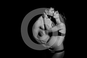 Monochrome portrait of happy loving couple in a moment of love and tenderness. Pregnant woman with hands over tummy.