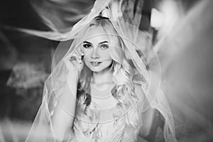 Monochrome portrait of sensuality and charming smiling bride.