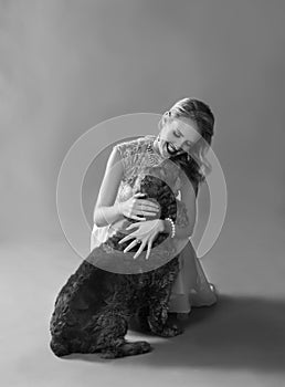 Monochrome portrait of woman playing with dog