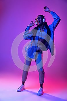 Monochrome portrait of young attractive happy woman in casual style outfit dancing isolated on very peri color