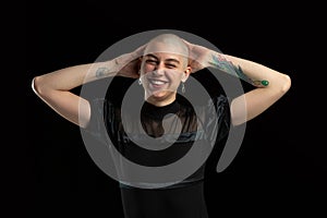 Monochrome portrait of young caucasian bald woman on black background