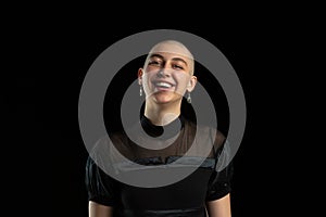 Monochrome portrait of young caucasian bald woman on black background
