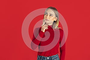 Monochrome portrait of young caucasian blonde woman on red background