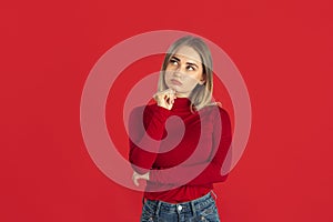 Monochrome portrait of young caucasian blonde woman on red background