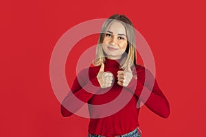 Monochrome portrait of young caucasian blonde woman on red background