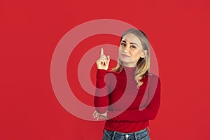 Monochrome portrait of young caucasian blonde woman on red background