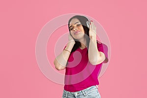 Monochrome portrait of young caucasian brunette woman on pink background