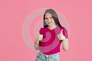 Monochrome portrait of young caucasian brunette woman on pink background