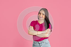 Monochrome portrait of young caucasian brunette woman on pink background